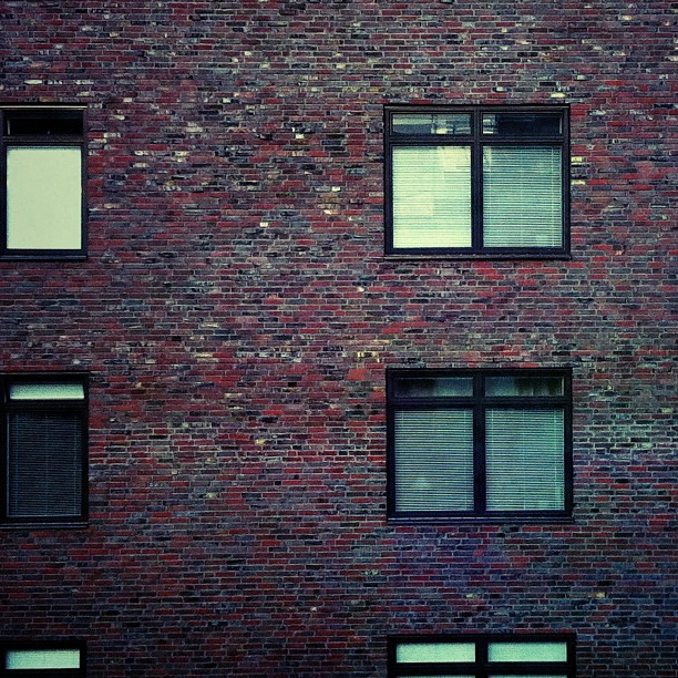 a brick building with three windows in front