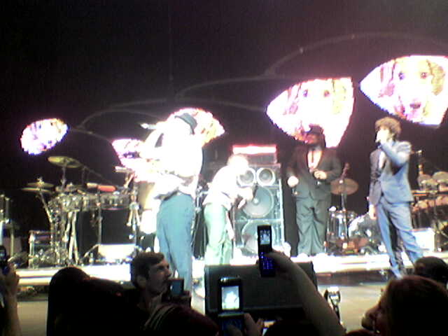 a band playing on stage with a cell phone