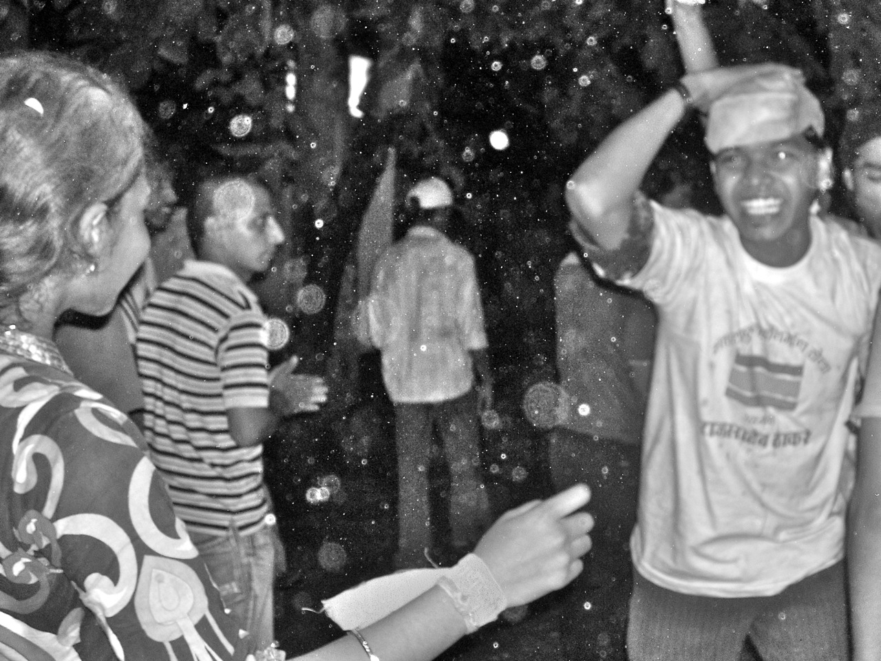 several people dance in the rain with umbrellas