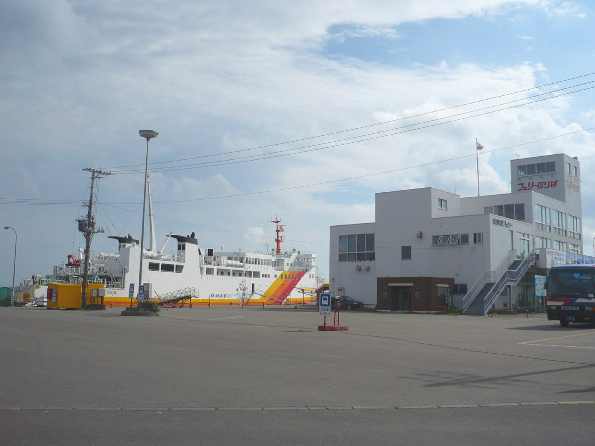 a large boat docked at a station with buildings in the background