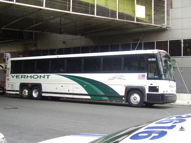 the front of a tour bus parked by the curb