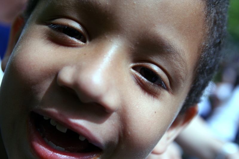 a child smiling for the camera in front of a group