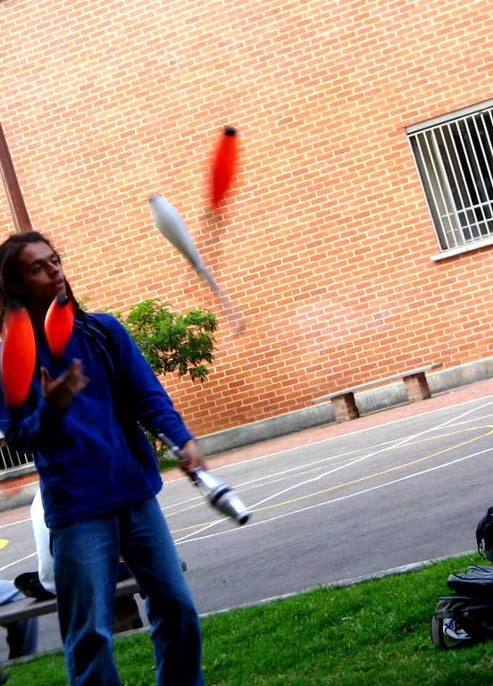 a woman is throwing orange frisbees on the grass