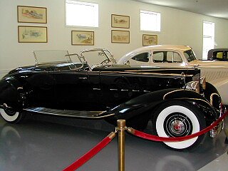 a vintage car on display inside of a museum