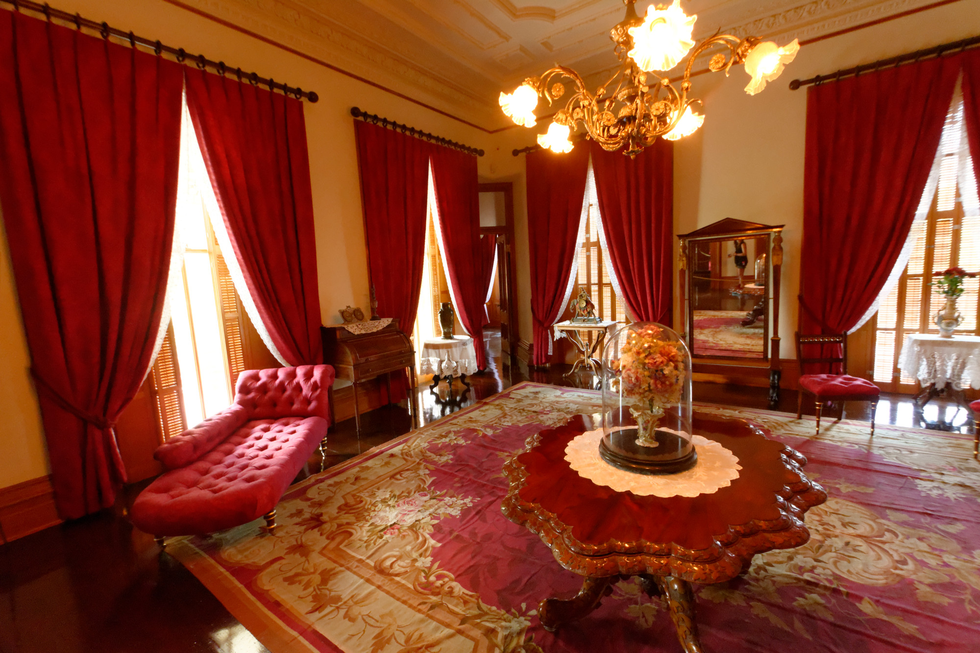 a large formal red room with red velvet couches