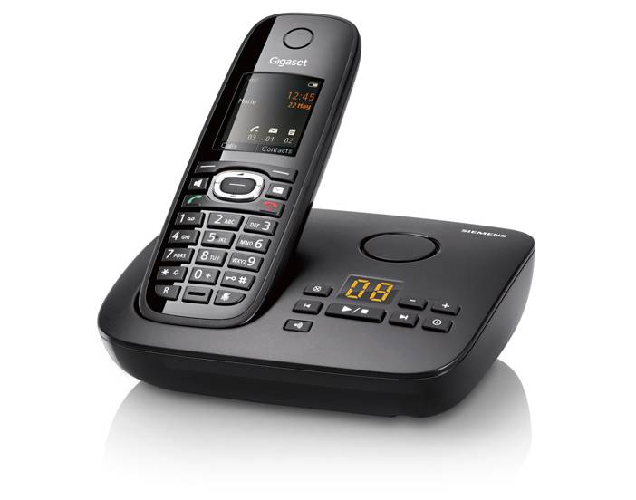 a black corded phone stands next to it's respective receiver