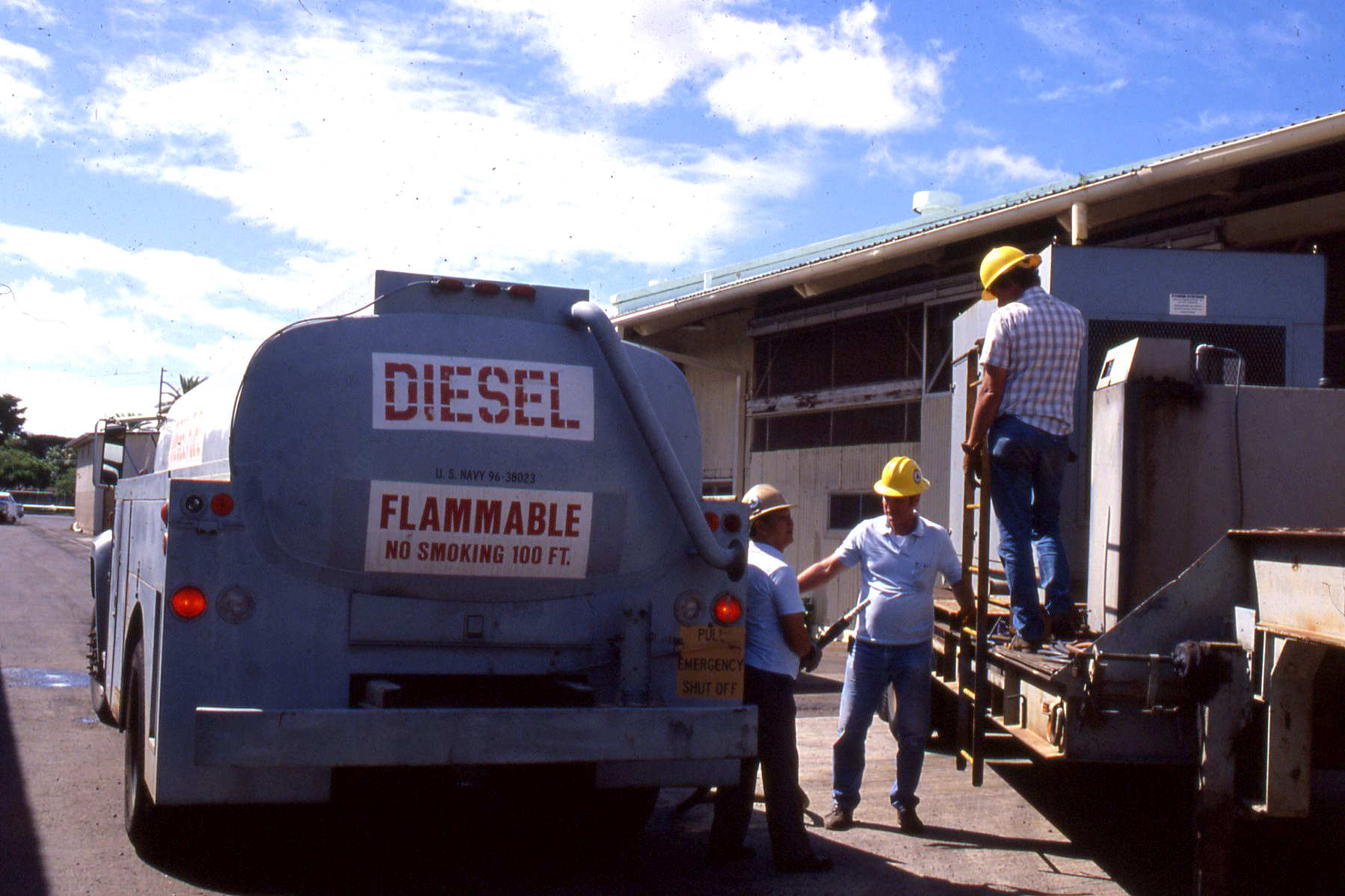 a group of workers and others loading a truck with a sign on it