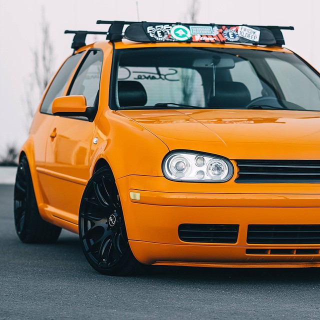 an orange car with a pair of skis on the roof