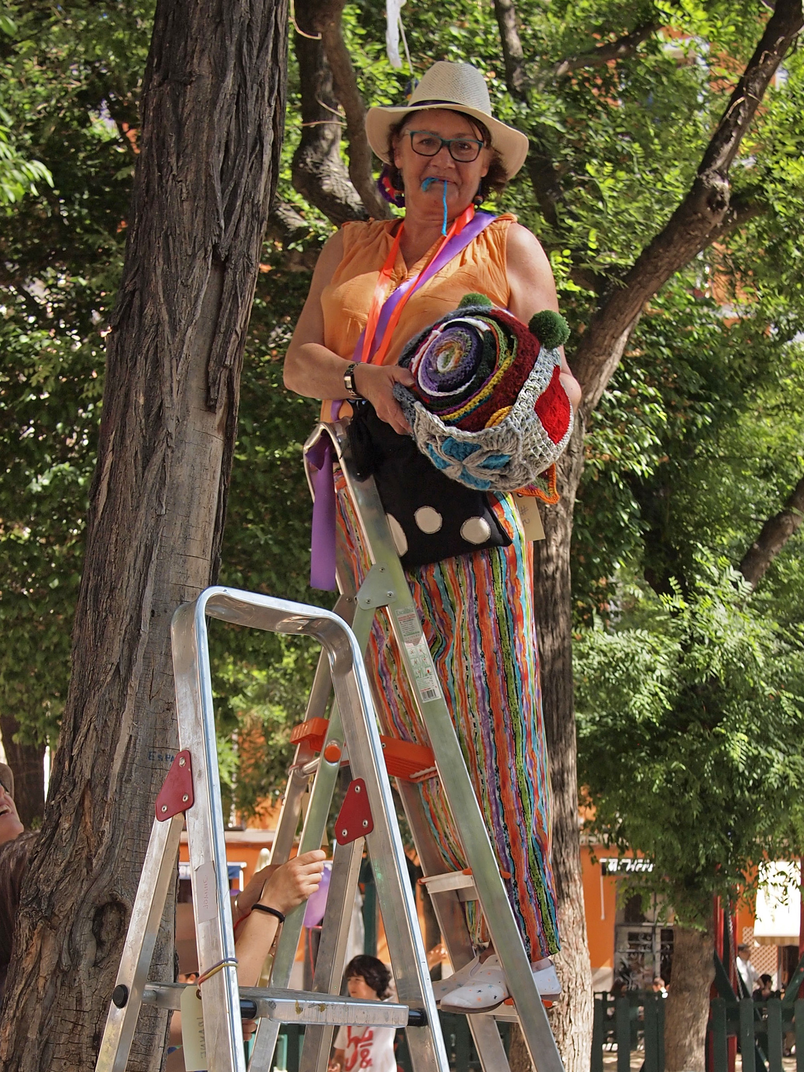 a woman is on a ladder wearing a hat