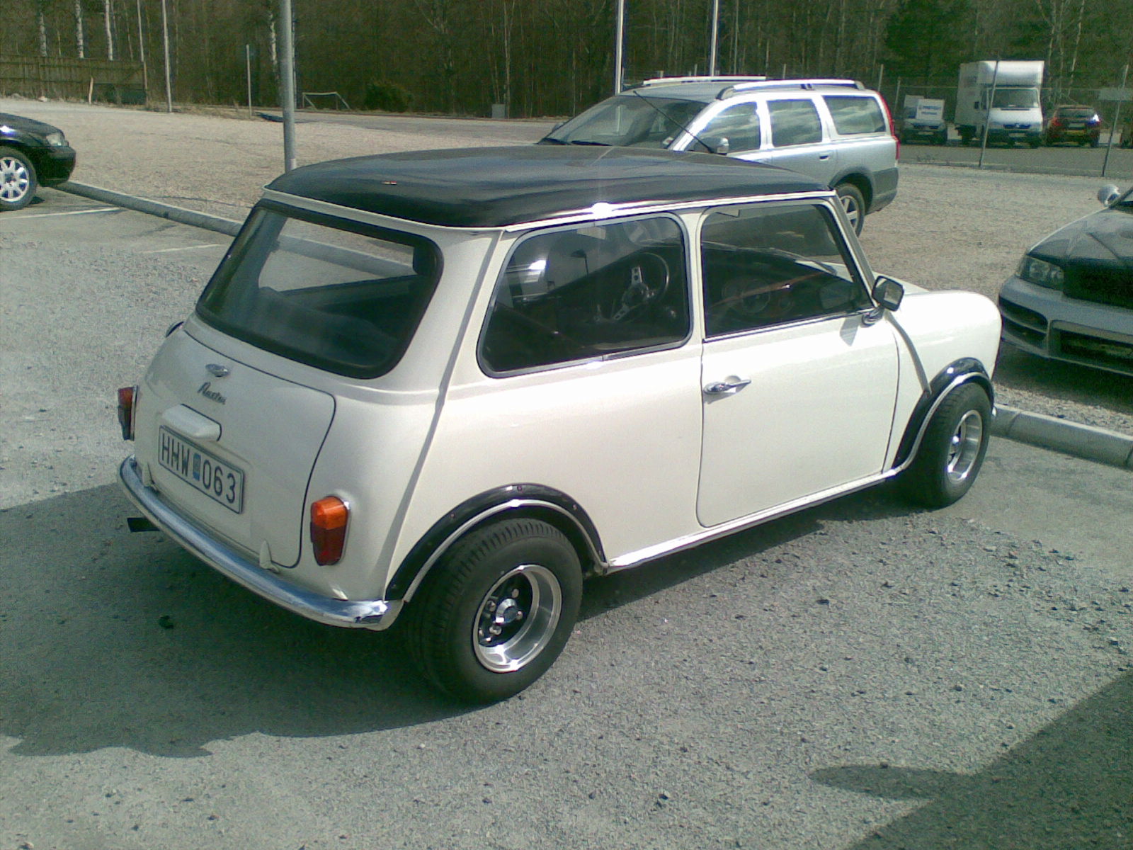 a small white car with an open top parked