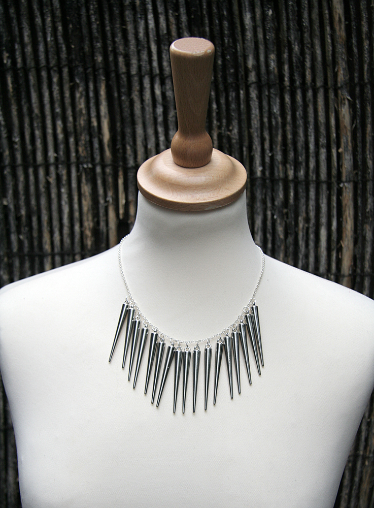 necklace with spiked spikes displayed on neck stand