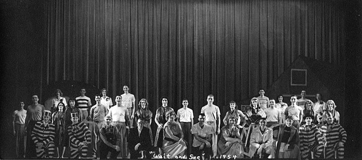 an old po shows a group of people standing in front of a stage