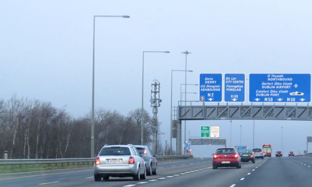 cars on highway near blue and white sign with directions