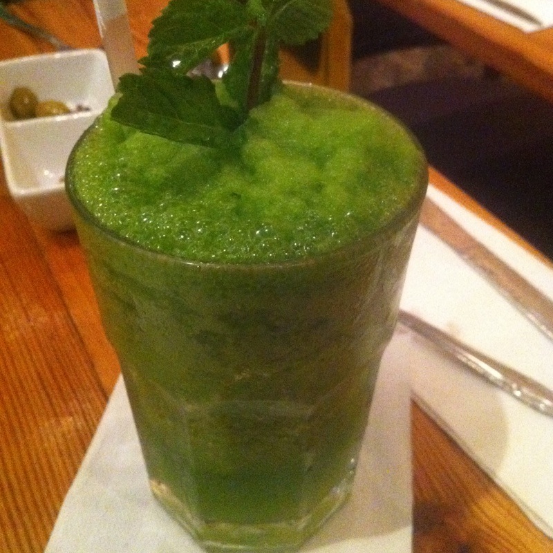 a green drink sitting on top of a table