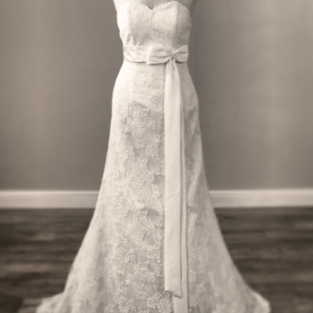 a white wedding dress hanging from a hanger