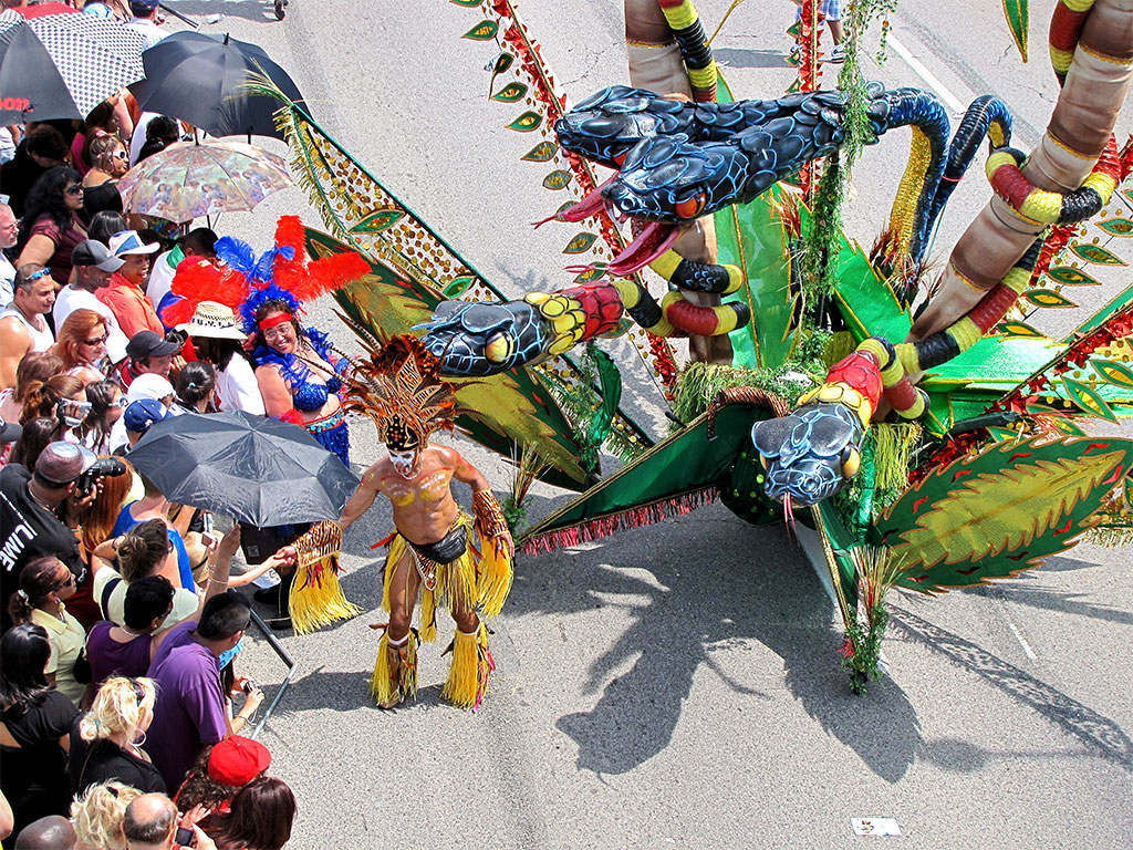 a group of people watch people dressed as dragon performers