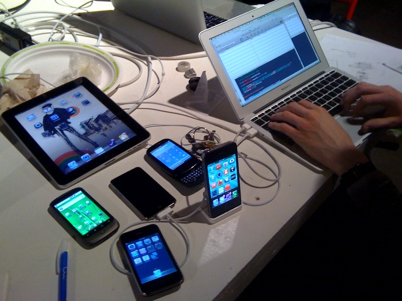 a man is using a laptop next to several devices on display