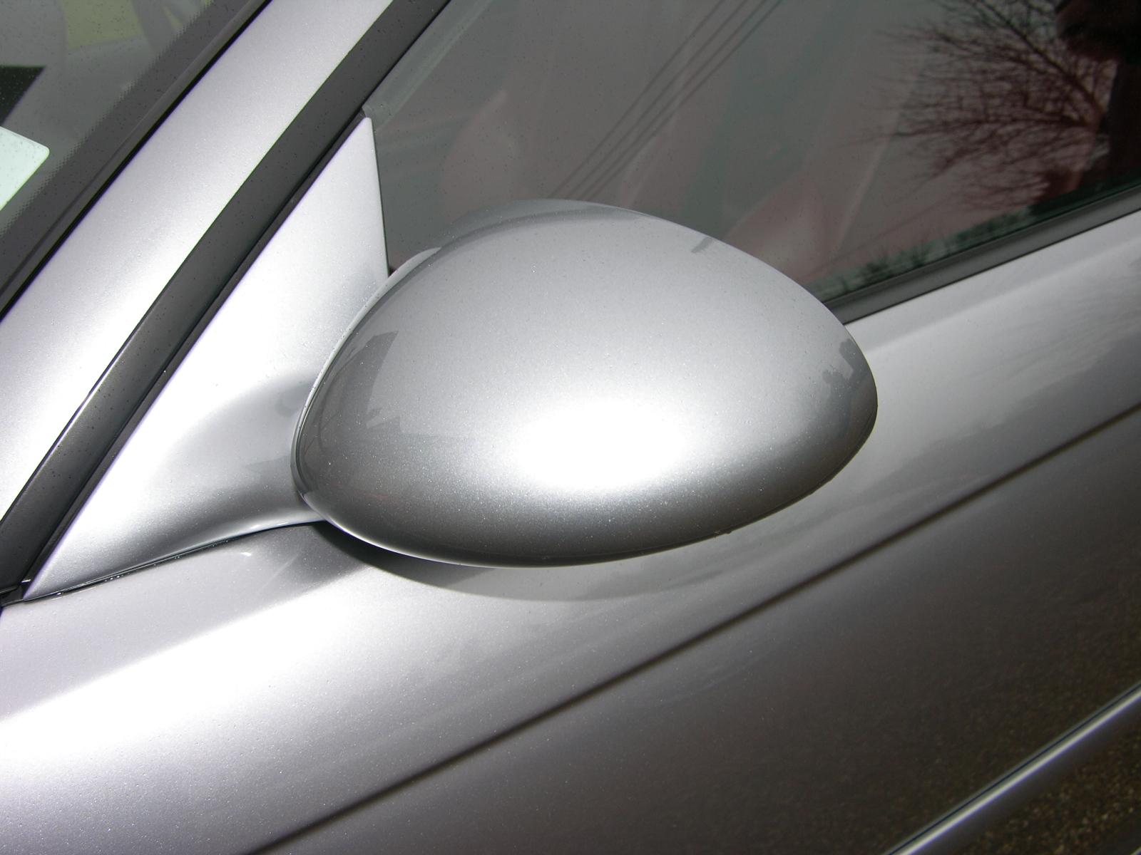 a silver car's side view mirror on the side of a vehicle