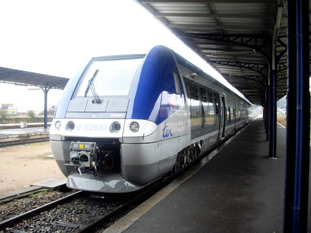 a white and blue train pulled up to a station