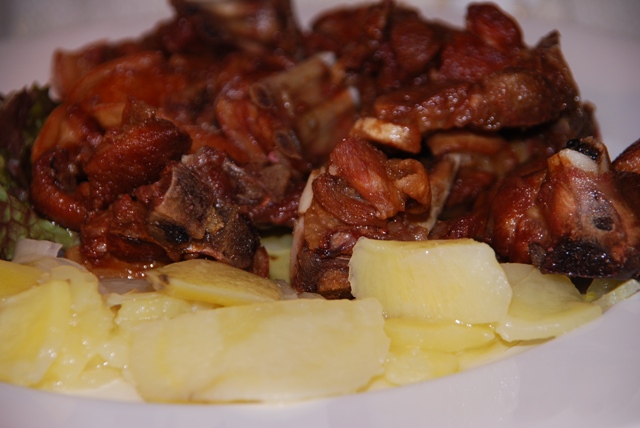 plate with meat, potatoes and potatoes on it