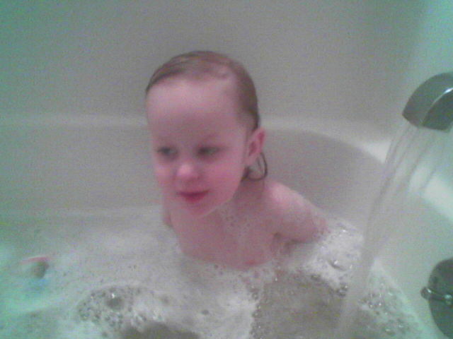 the little child is taking a bubble bath