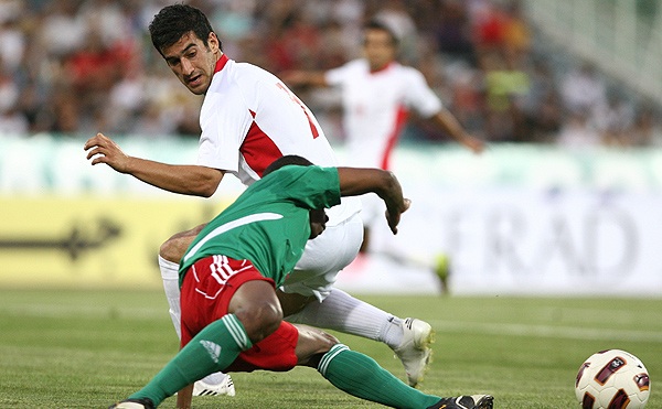 two soccer players colliding to control the ball during a game