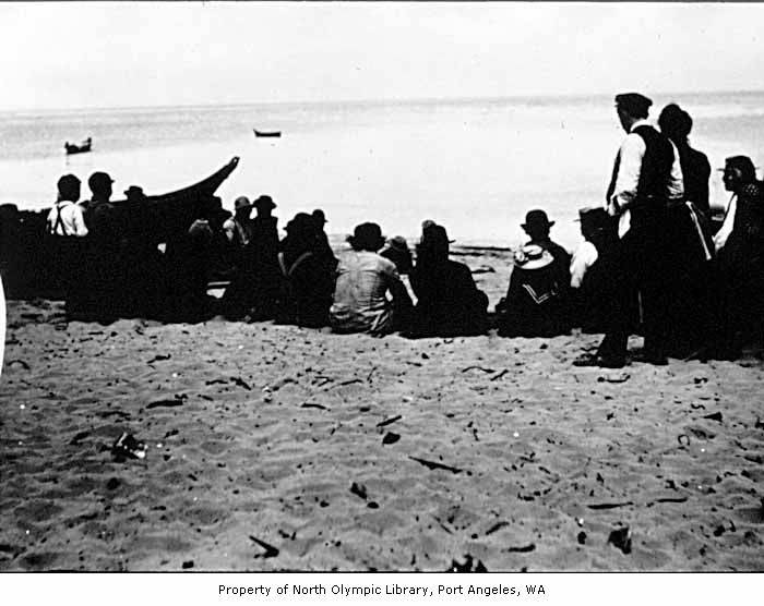 a group of people sitting around each other on the beach