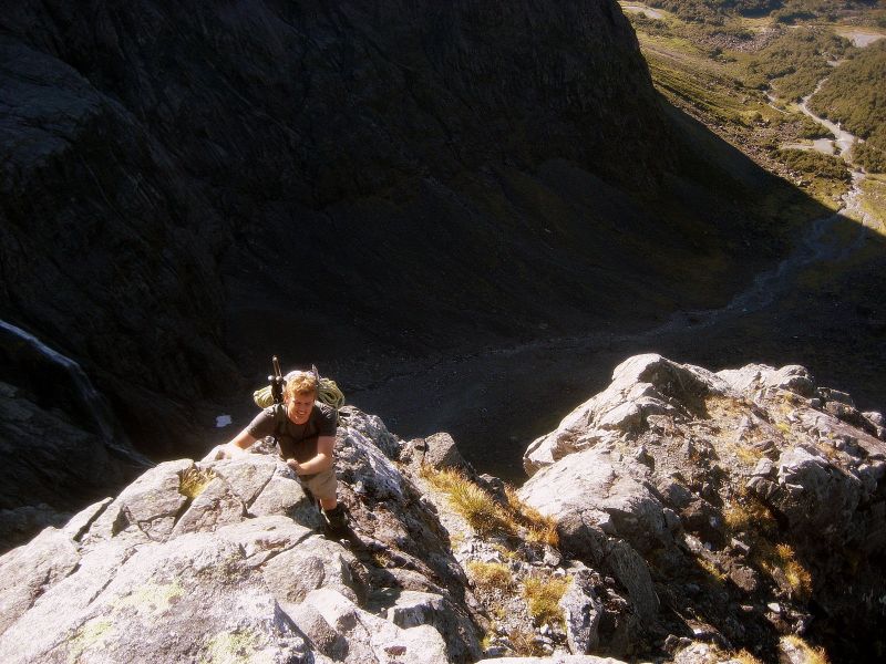 a person on top of a hill with mountains in the background