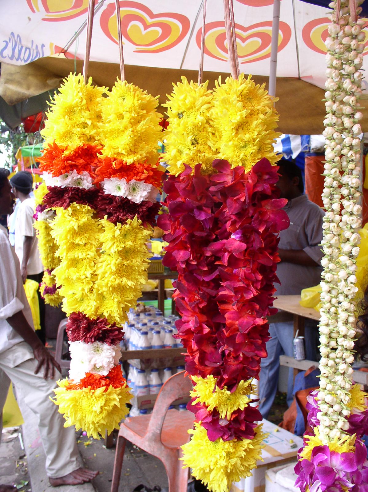 a man is standing near some large paper flowers