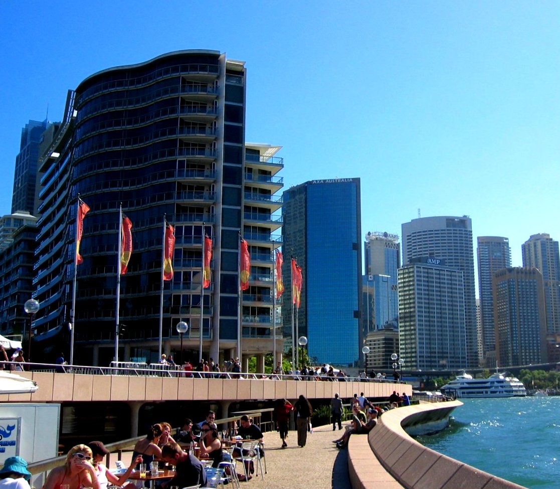 several people sitting on benches outside near water