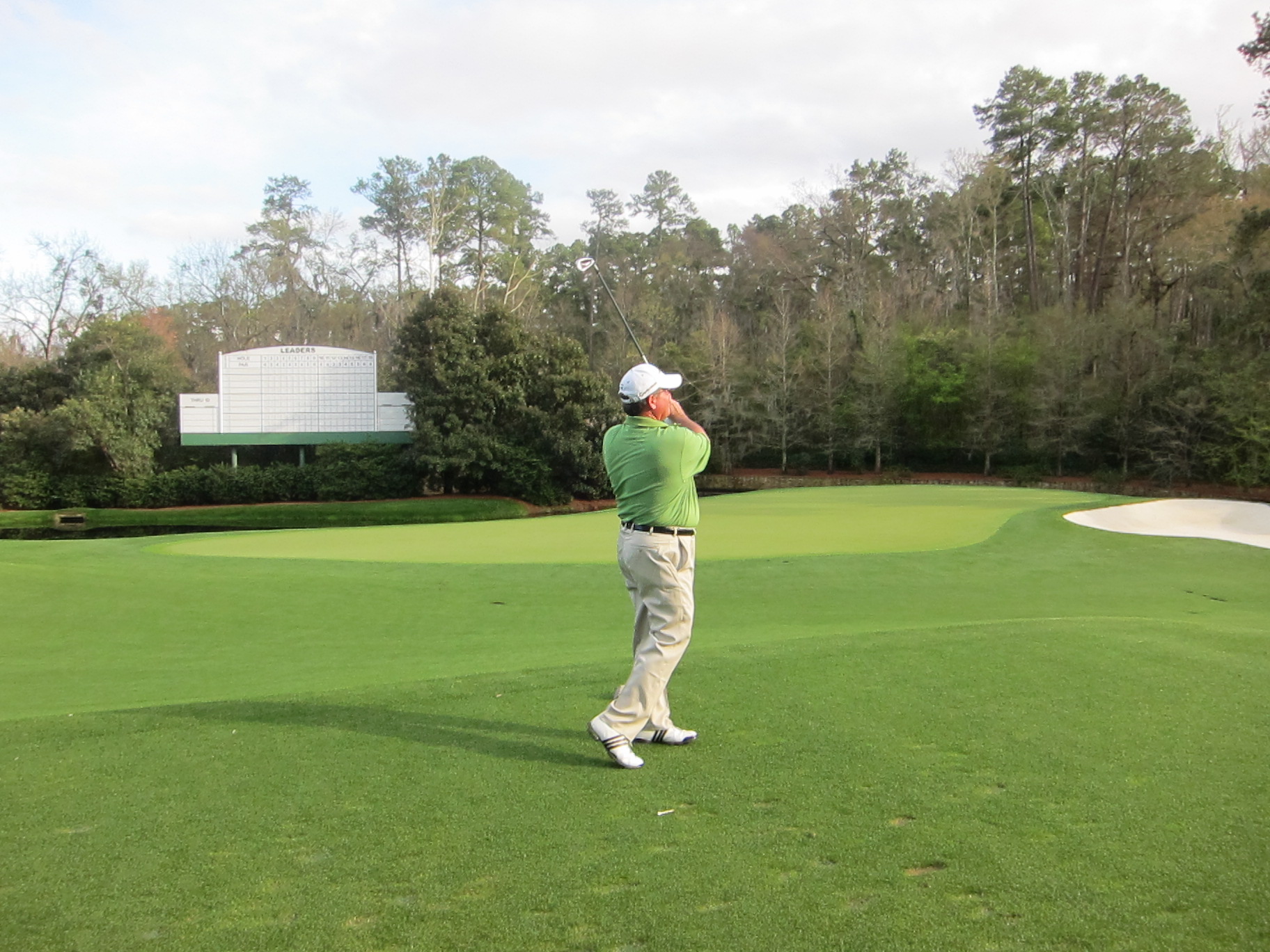 a man hitting a golf ball from the hole