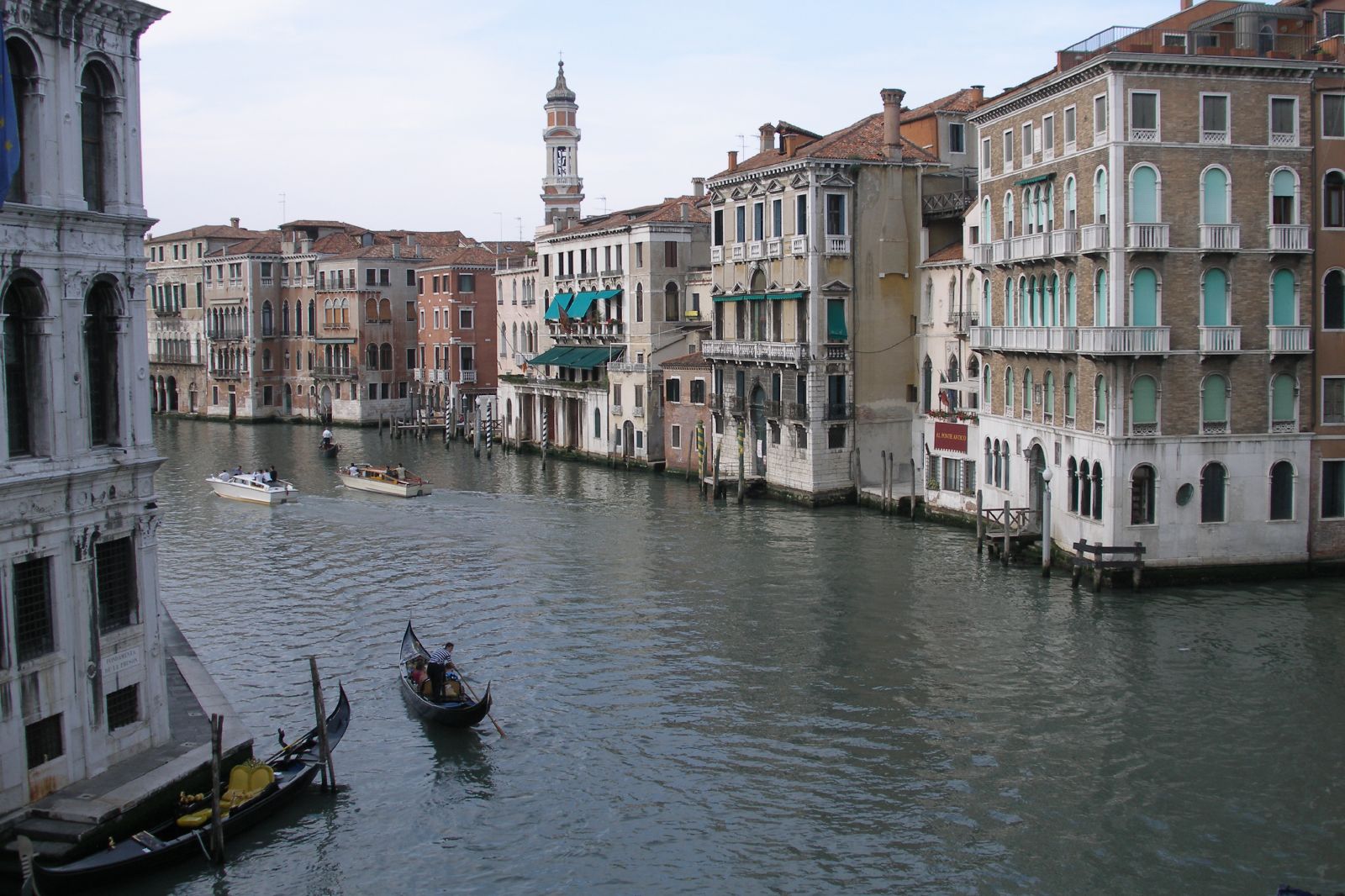 a canal filled with lots of boats next to tall buildings