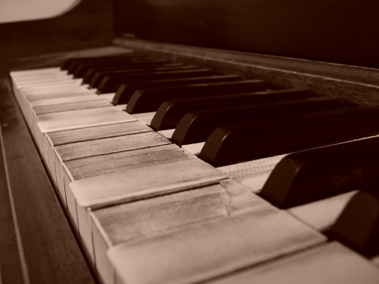 old piano with wooden edges and dark stained paint