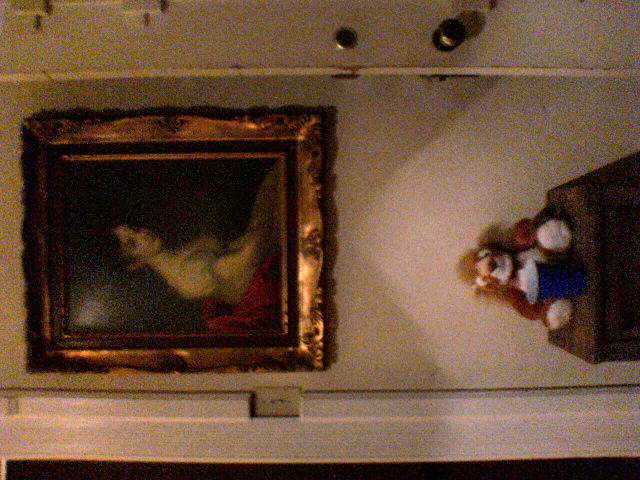 a painting hanging from the ceiling and a teddy bear