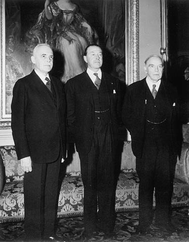 four men standing in front of a painting