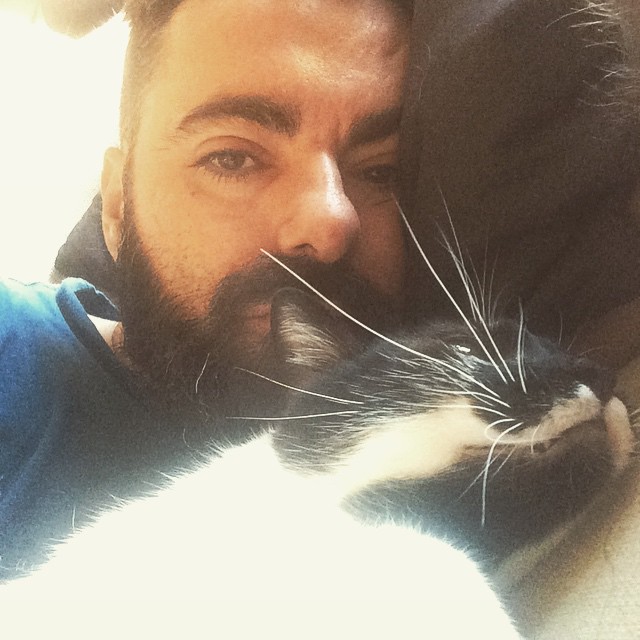 a man with a cat cuddling his face on the man