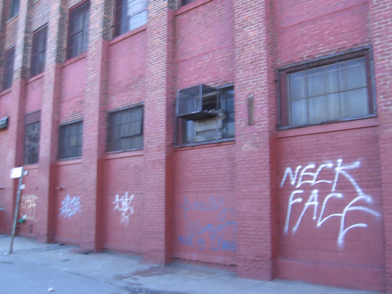 the windows in the building have been covered with graffiti