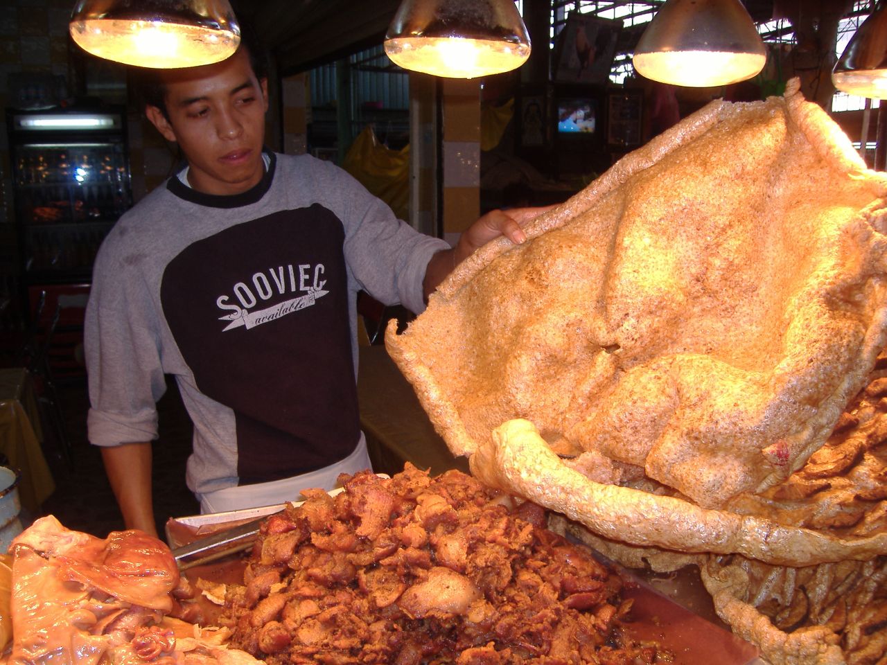 a man standing next to large stack of food