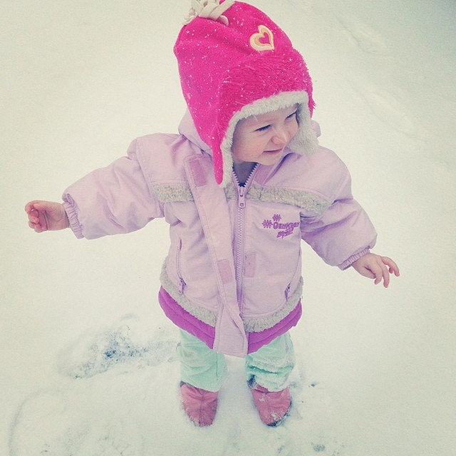 little girl in pink jacket walking on snow
