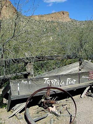 a wooden wagon sitting on top of a gravel field