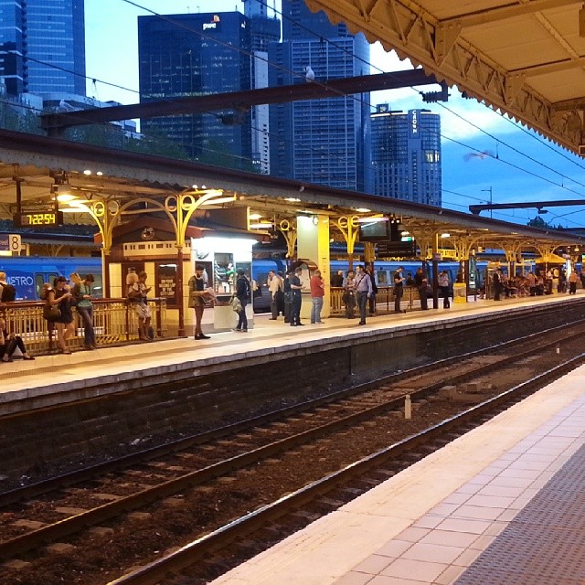 a train platform with several people waiting on the platforms