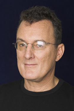 a man wearing glasses is looking at the camera