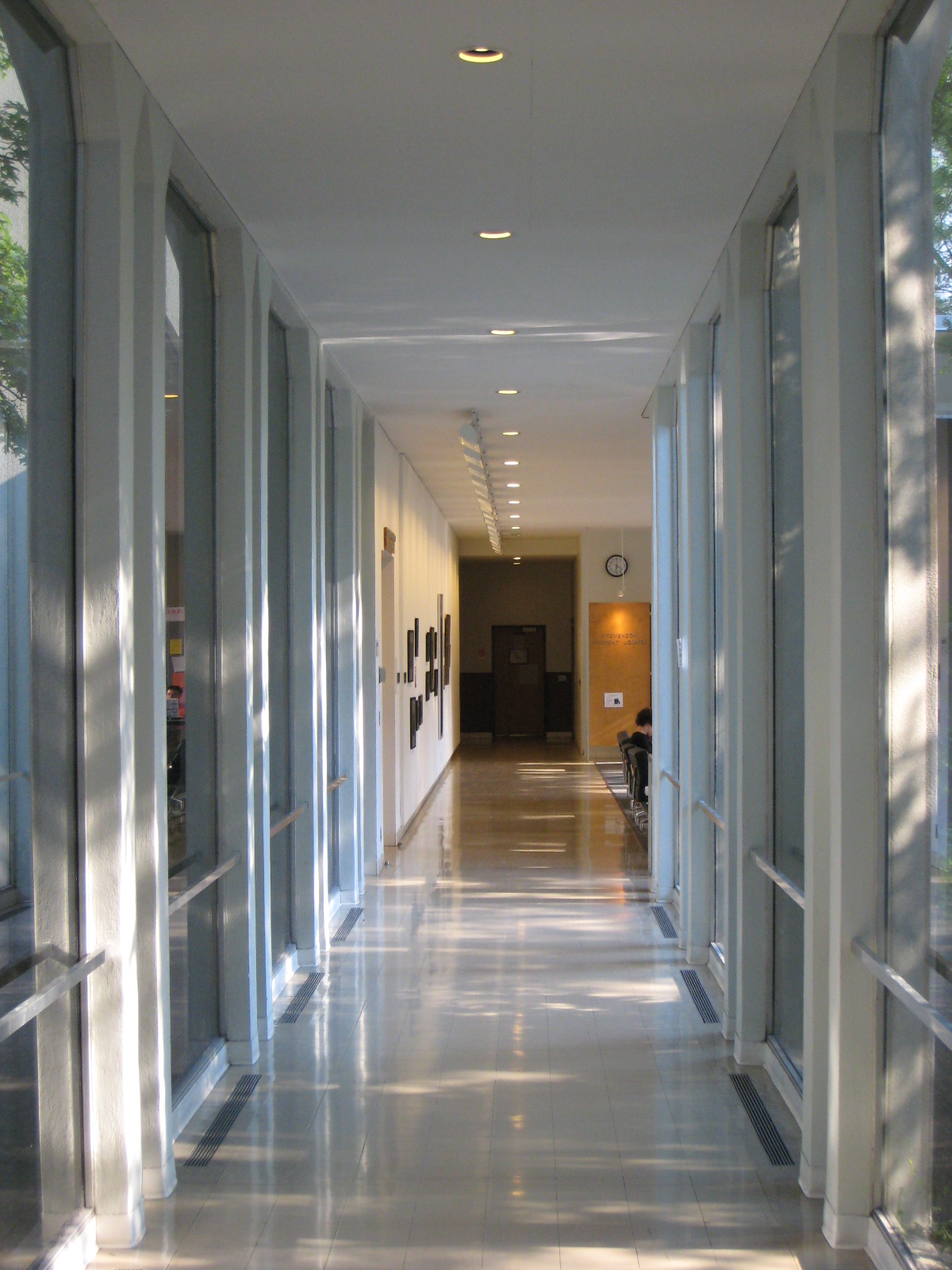 a long hallway with a clock on the wall and several windows