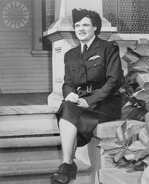 a women in uniform sits on stairs posing for the camera