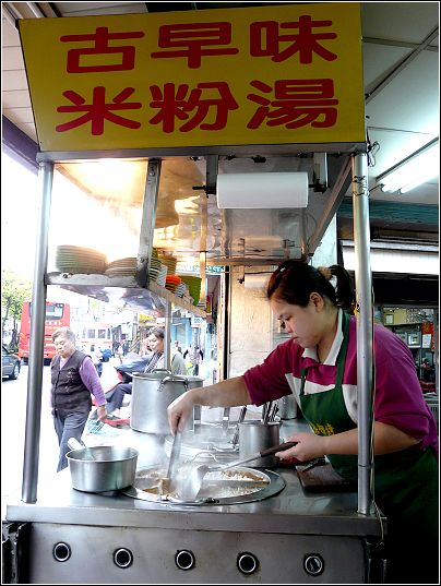 a woman in an oriental restaurant setting preparing food