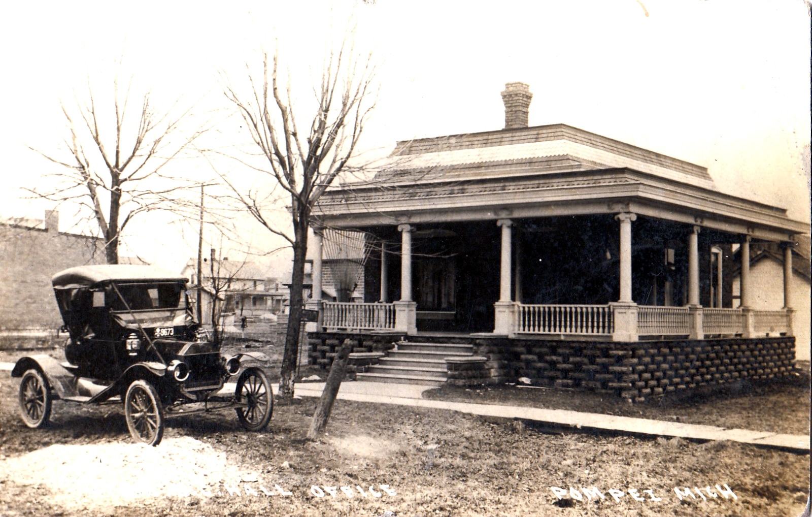 old black and white pograph of a horse drawn car in front of a home