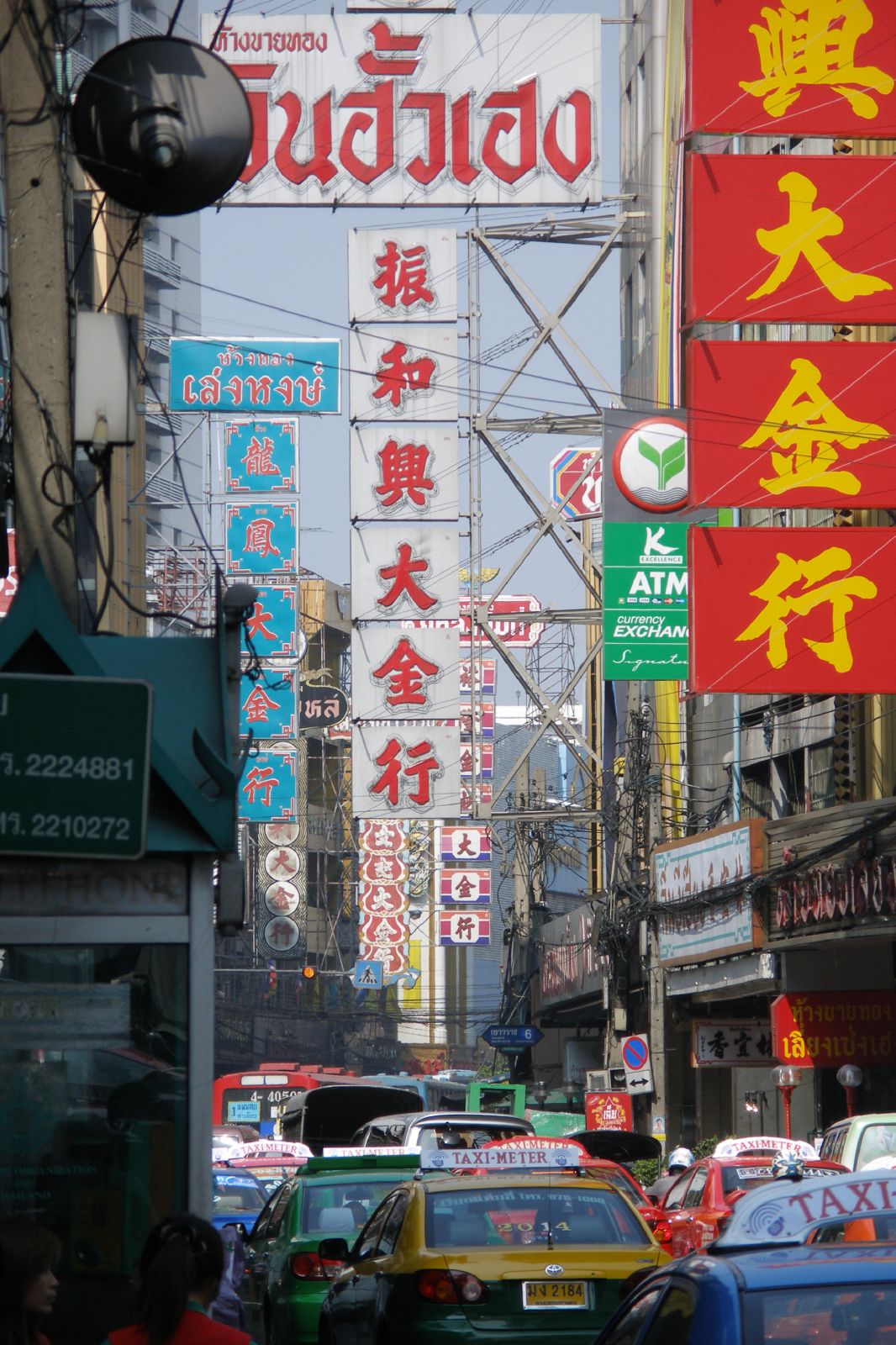 an asian street with cars, trucks and pedestrians