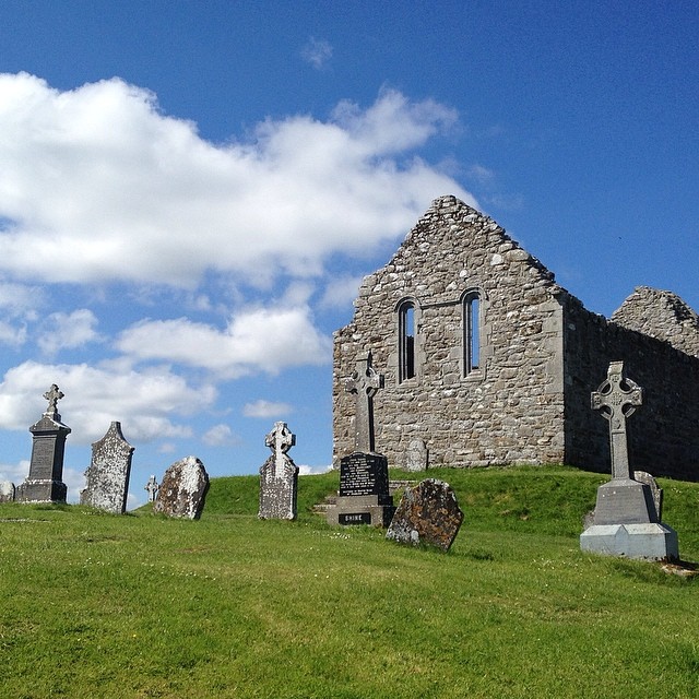 cemetery in a stone building with green grass and sky background