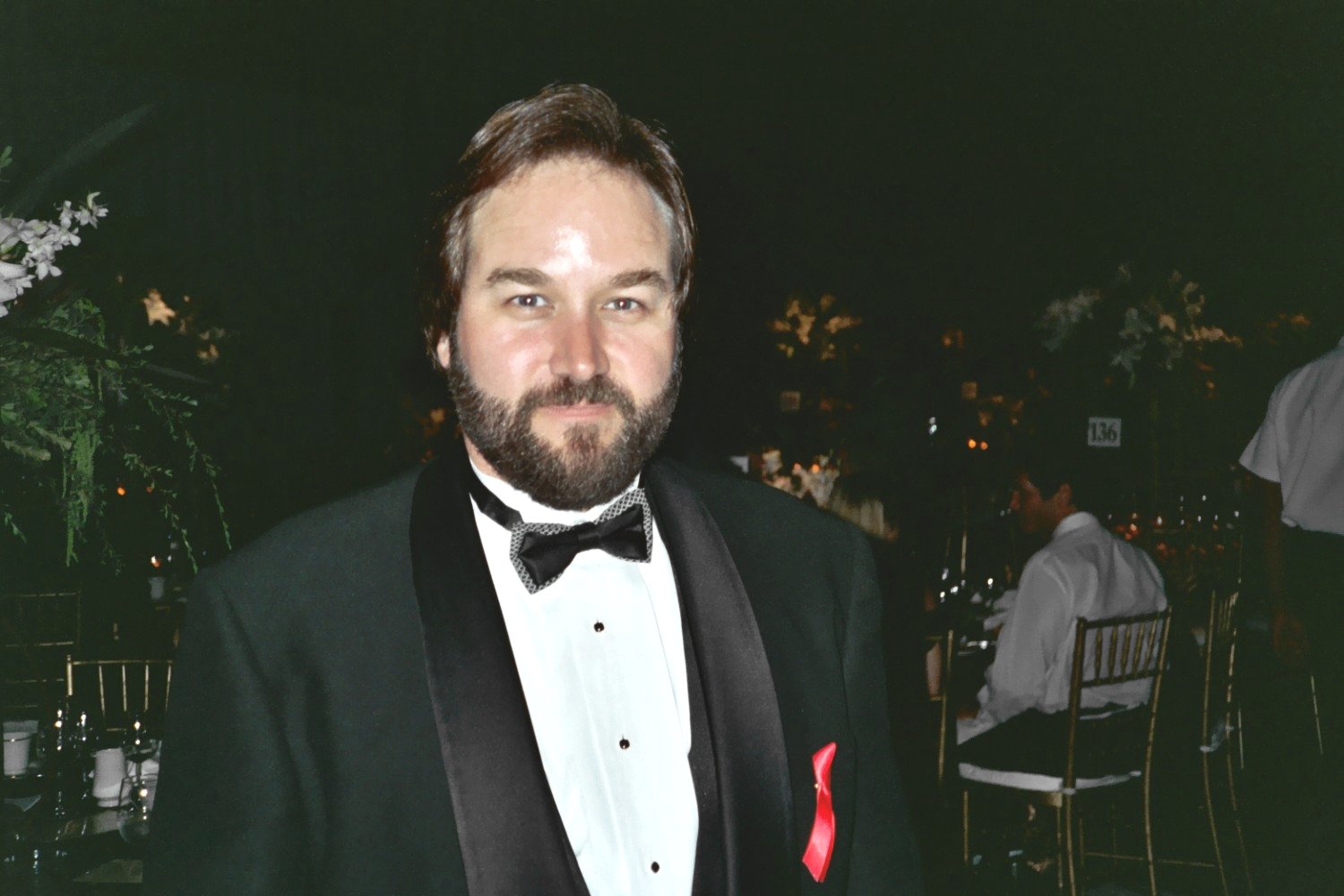 a man in tuxedo standing and posing for a po