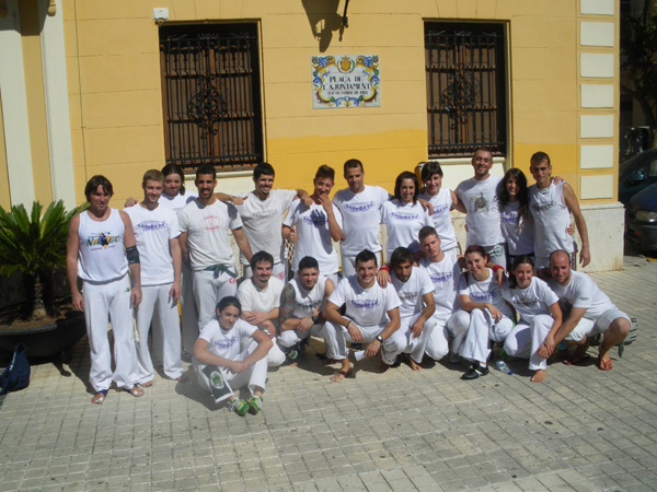 several people dressed in white and posing for a group po